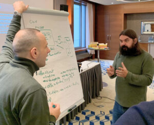 due persone che parlano di fronte a una flipchart durante un corso